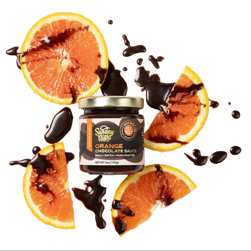 Orange slices drizzled in chocolate sauce surround a small container of Orange Chocolate Sauce.