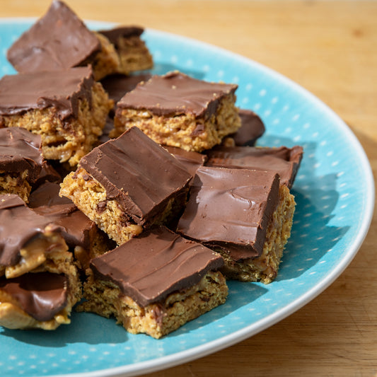 Sunday Night® Eileen’s Scotcheroos stacked on a blue plate